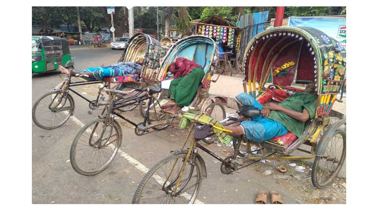 তীব্র গরমে অতিষ্ঠ জনজীবনে সারাদিন রিকশা চালিয়ে বিশ্রাম হিসেবে একমাত্র রিক্সার মাঝে ঘুমিয়ে পড়েছে চালকরা।কদমতলি মোড় এলাকা থেকে তোলা ছবি